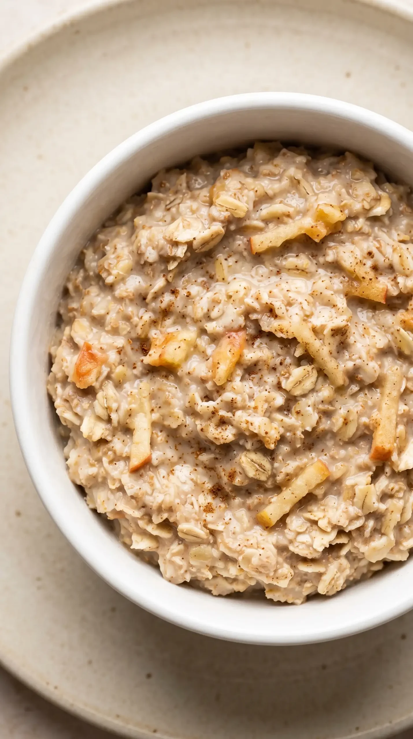 Creamy apple bran oatmeal showing oats, grated apple pieces, and bran texture