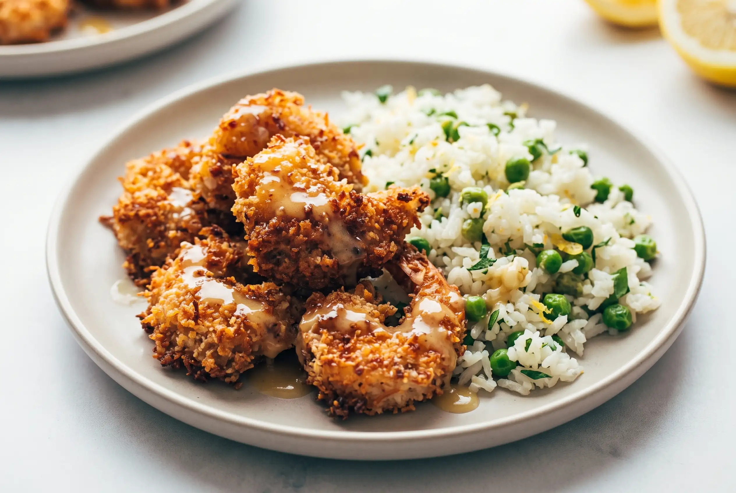 Baked coconut shrimp with honey butter sauce served with jasmine rice and green peas