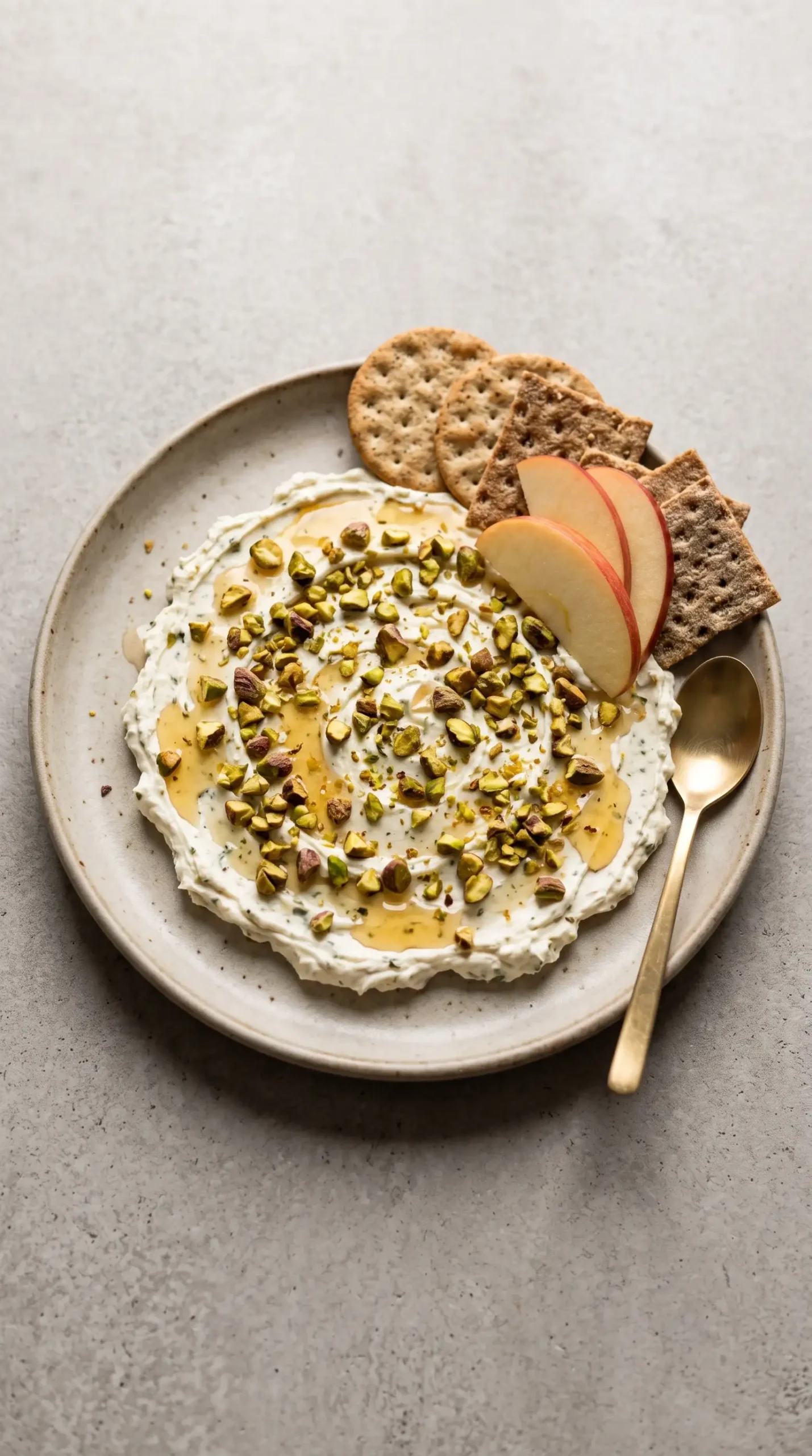 Finished Boursin appetizer platter with pistachios, hot honey, crackers, and apple slices