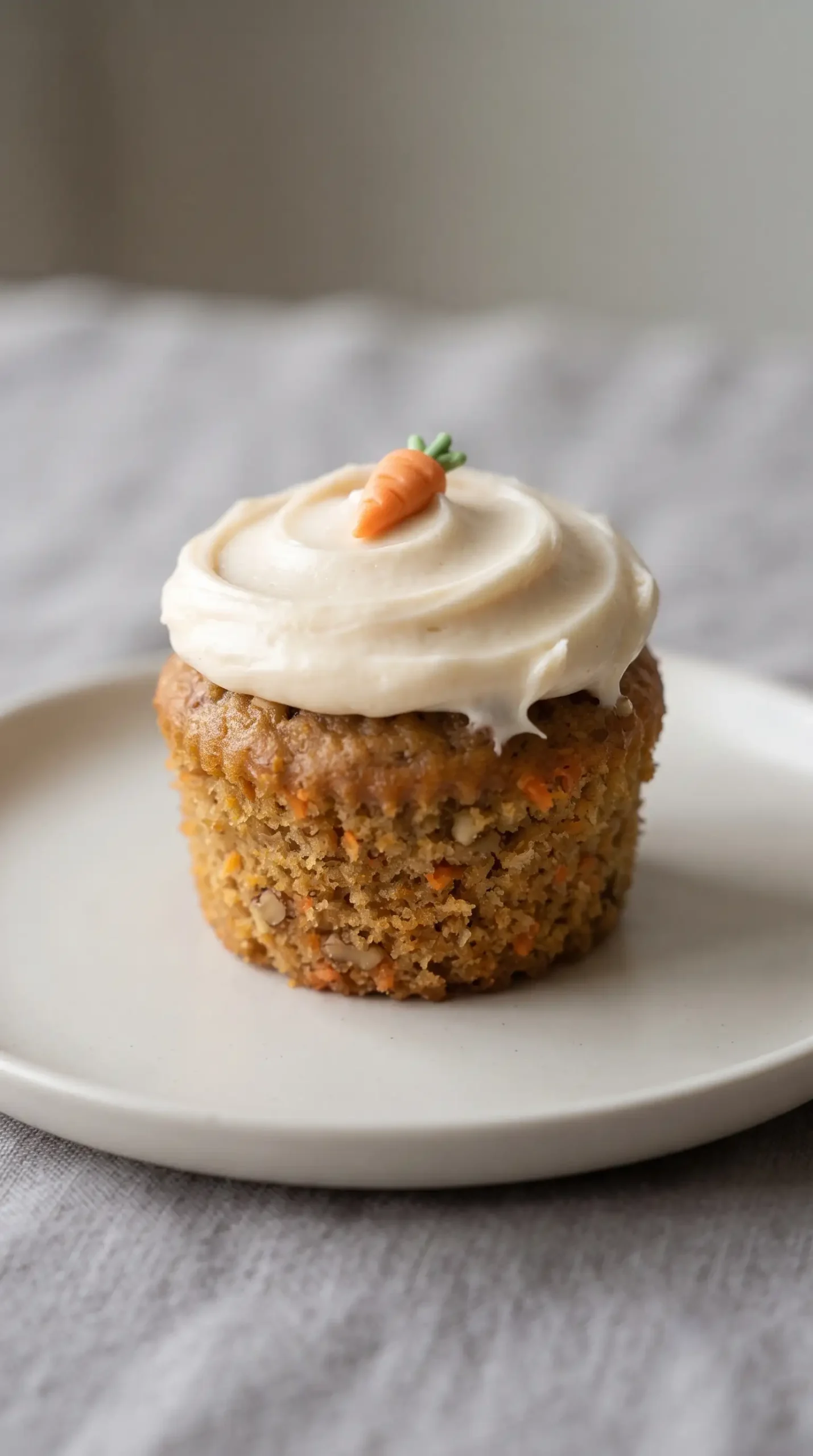Carrot cake cupcake with a swirl of cream cheese frosting