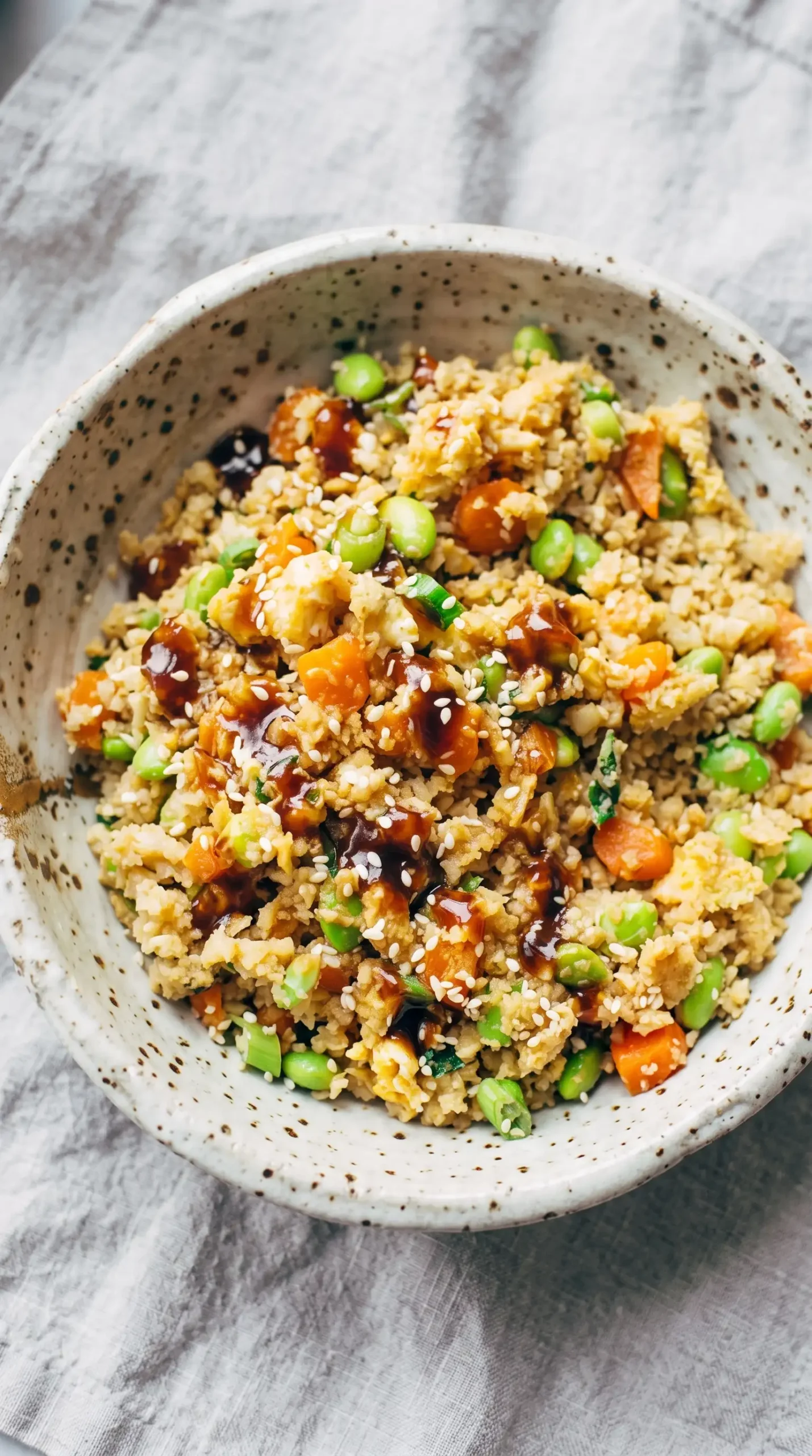 Finished cauliflower fried rice with eggs, carrots, edamame, and green onions