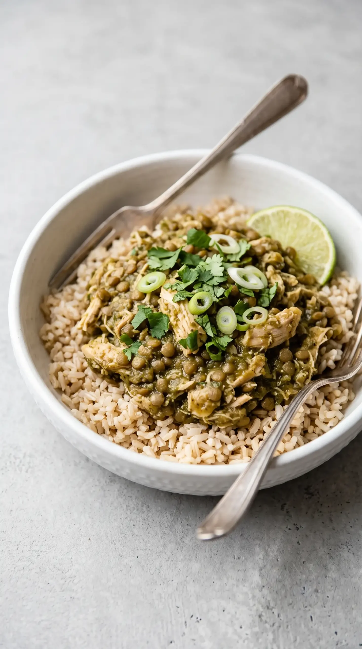 Finished cilantro lime chicken bowl with rice, lentils, salsa verde, and lime