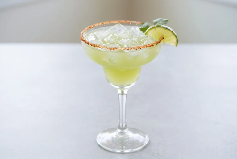 Non alcoholic margarita with jalapeño cilantro syrup in a chili lime rimmed glass
