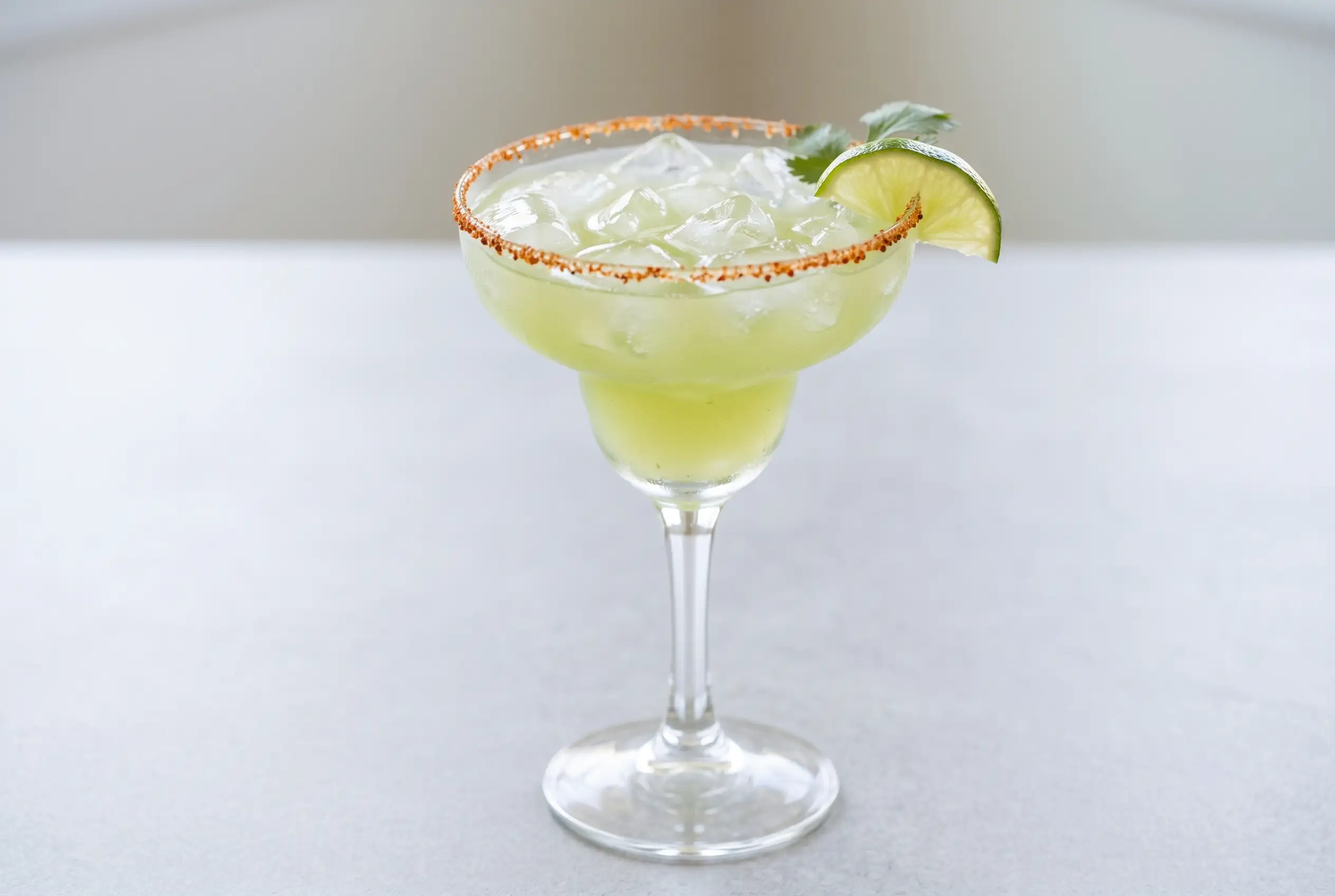 Non alcoholic margarita with jalapeño cilantro syrup in a chili lime rimmed glass