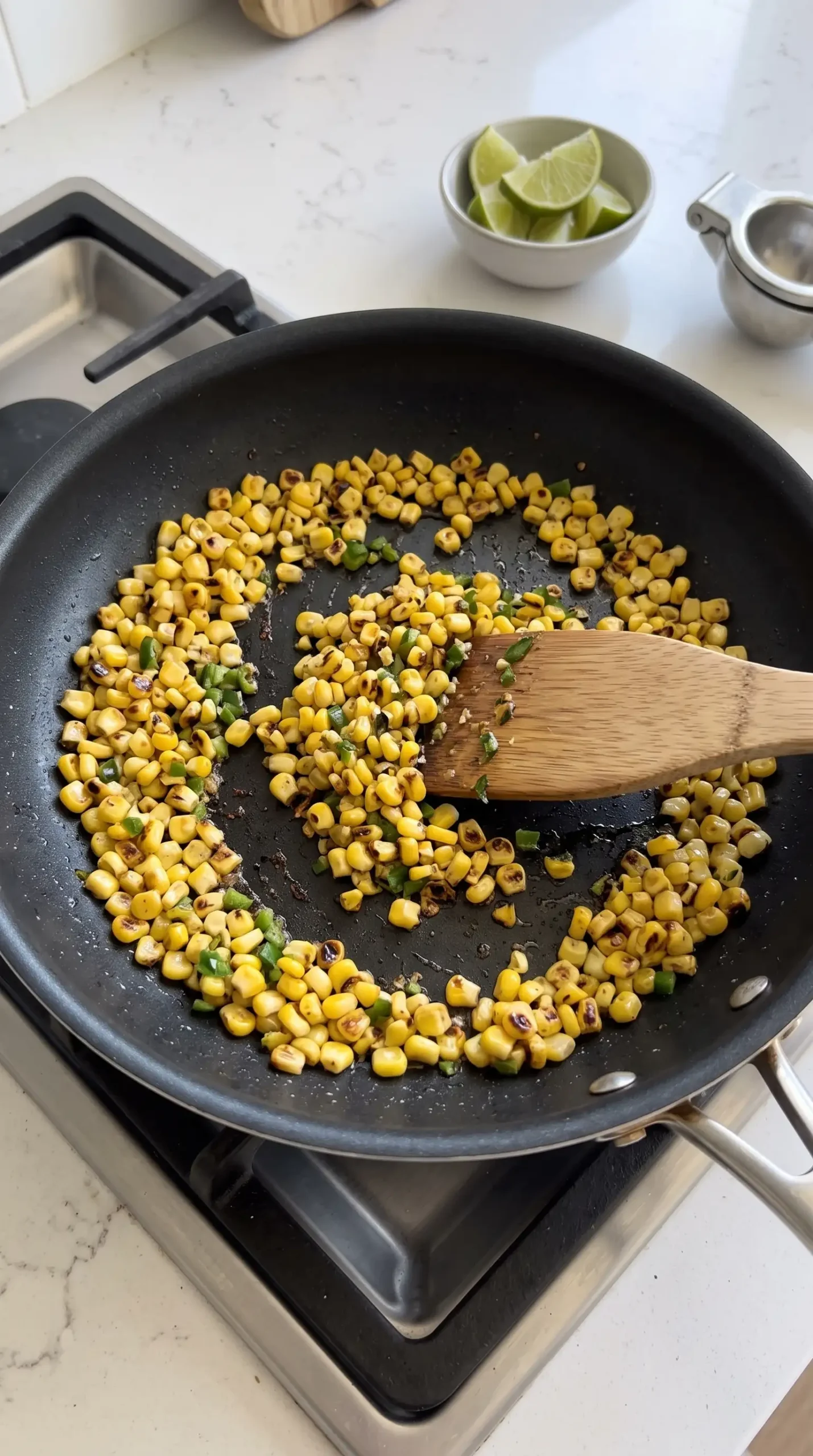 Charred corn and jalapeño mixture cooking in a skillet for Brussels sprouts tacos
